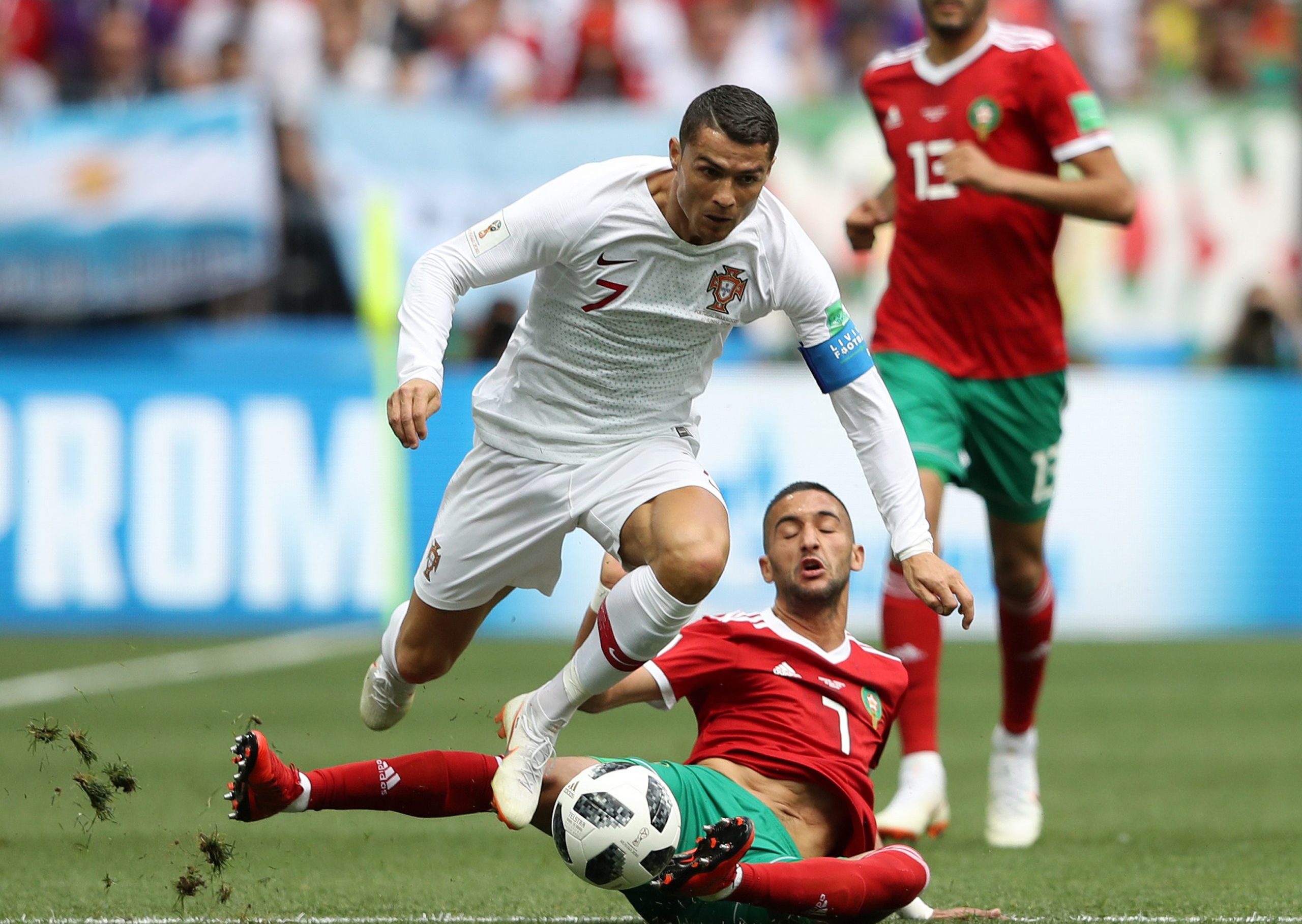 Cristiano Ronaldo of Portugal skips a sliding challenge from Hakim Ziyach of Morocco.